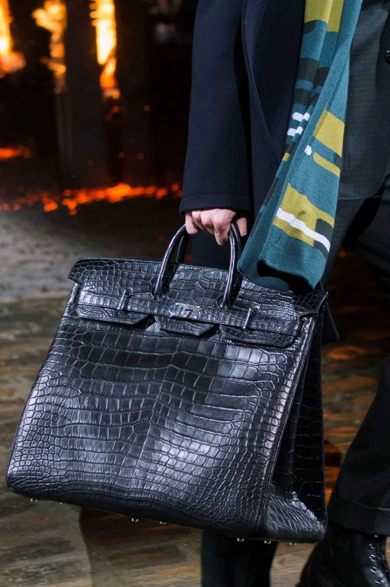 A black matte crocodile Hermès Haut à Courroies carried on the runway