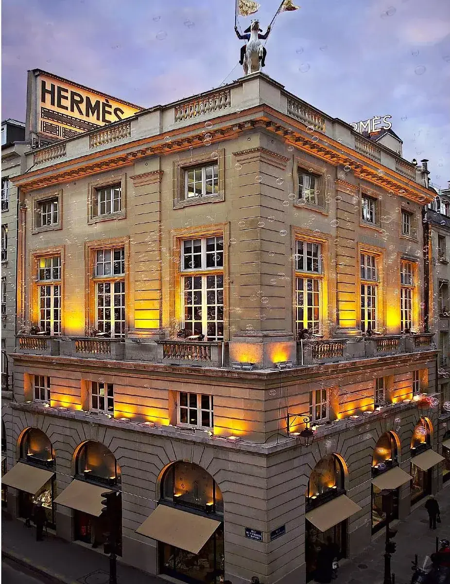 The Hermès flagship at 24 Faubourg Saint-Honoré, Paris, lit at dusk