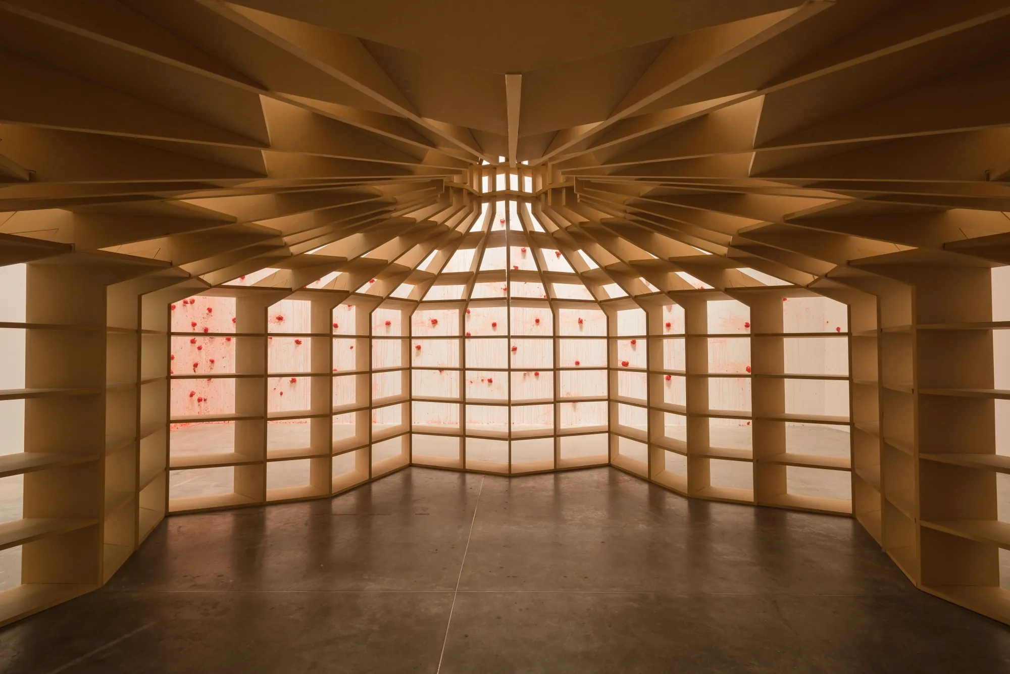 A domed reading room of wooden shelves by Los Carpinteros