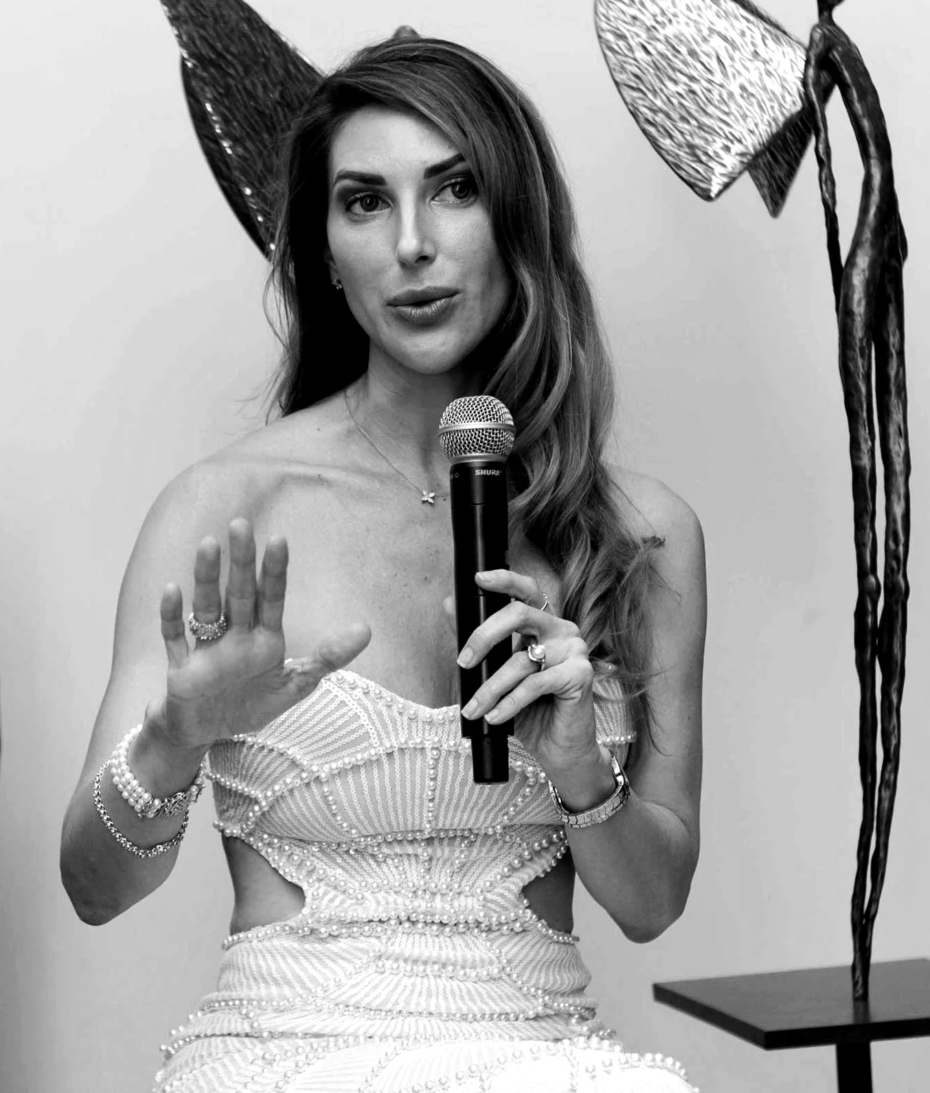 Ada Da Silva speaking beside one of her winged bronze figures